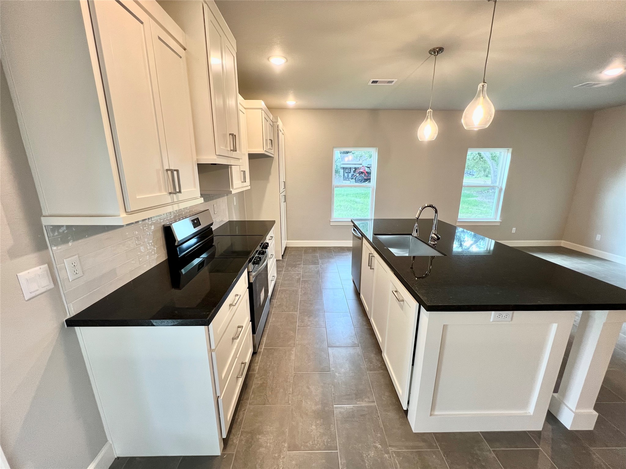 1007 South Anderson Street Angleton, TX 77515 - Photo 7 of 18 a kitchen with granite countertop a sink and a stove top oven