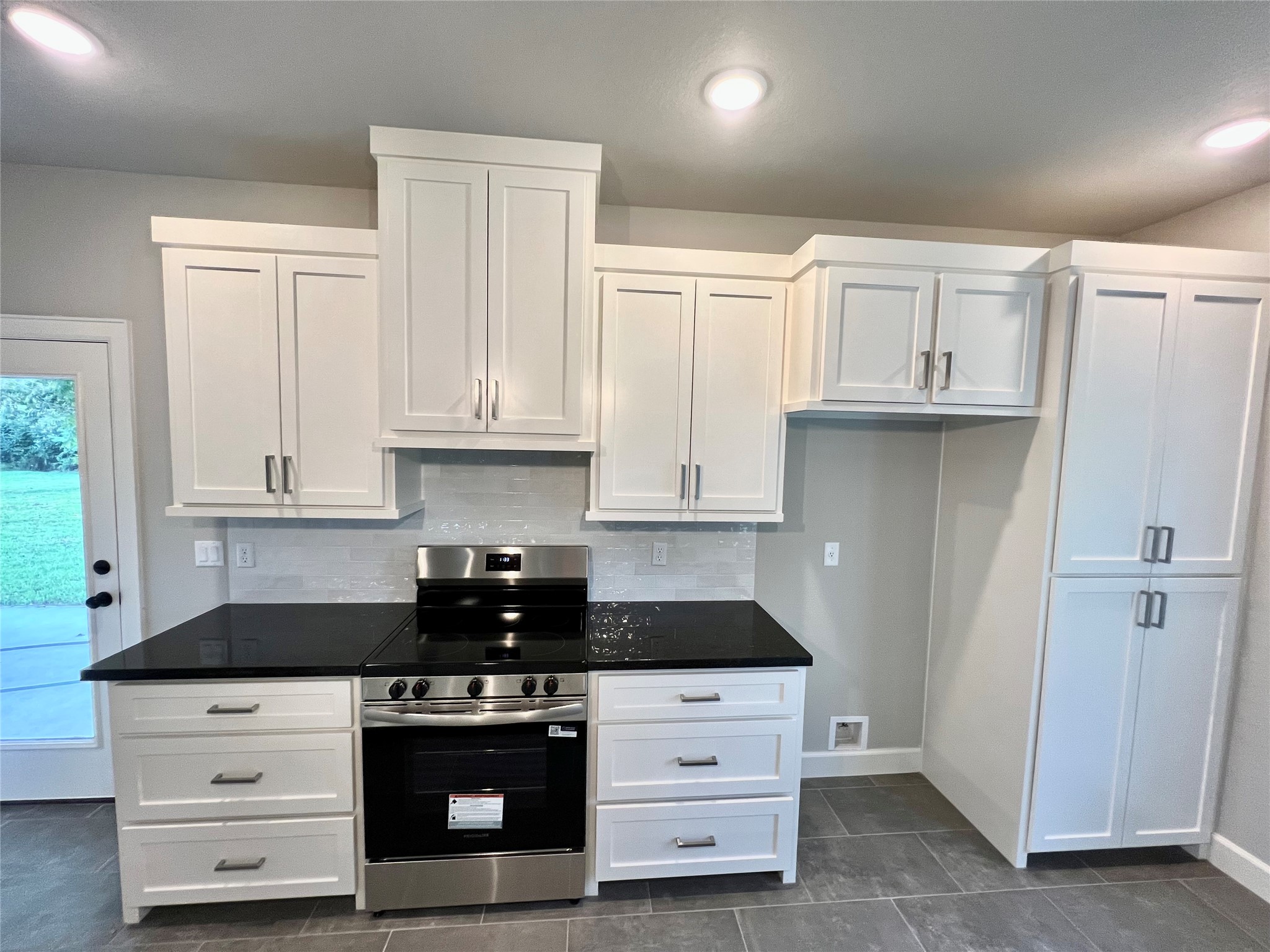 1007 South Anderson Street Angleton, TX 77515 - Photo 8 of 18 a kitchen with granite countertop white cabinets and black appliances