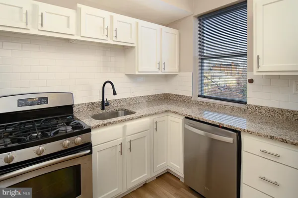 a kitchen with granite countertop cabinets stainless steel appliances and sink