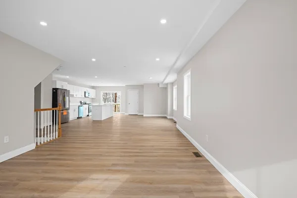 a view of empty room with wooden floor