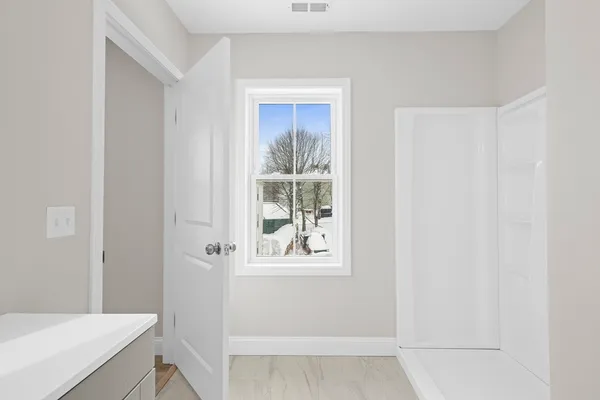 a bathroom with a window and a shower