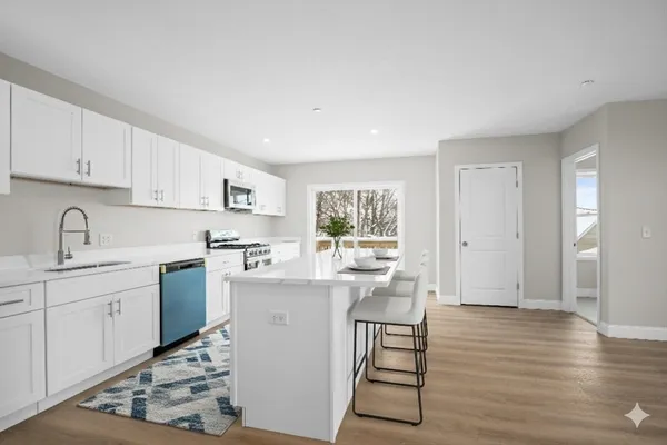 a kitchen with a sink cabinets and wooden floor