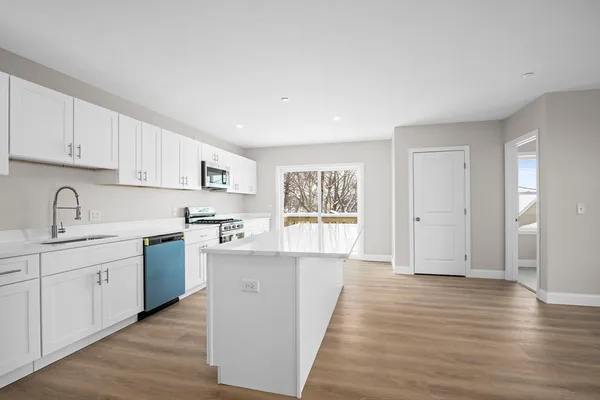 a kitchen with cabinets and wooden floor