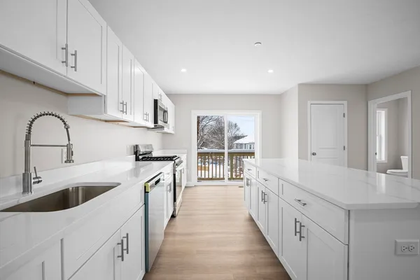a large kitchen with a sink and cabinets
