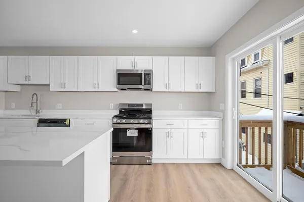 a kitchen with stainless steel appliances a stove a sink a microwave and cabinets