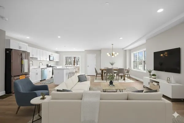 a living room with furniture kitchen view and a flat screen tv