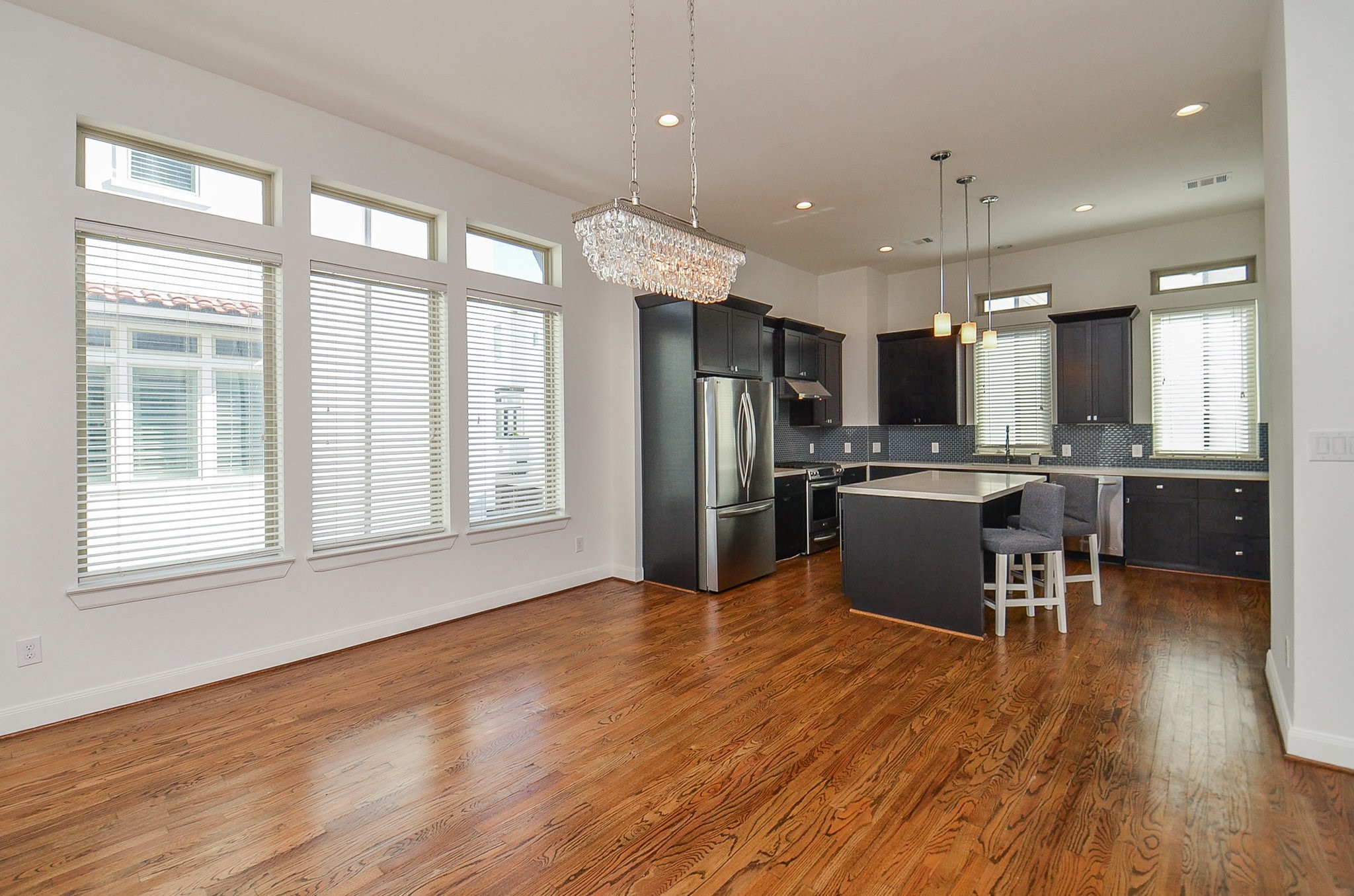 1245A Bonner Street, Unit B Houston, TX 77007 - Photo 17 of 36 a kitchen with stainless steel appliances kitchen island granite countertop a refrigerator a stove top oven a sink dishwasher and white cabinets with wooden floor