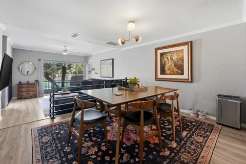 a dining room with wooden floor a chandelier