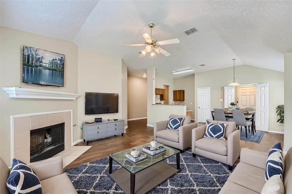 2210 Sumac Drive Forney, TX 75126 - Photo 3 of 20 a living room with furniture a flat screen tv and a fireplace