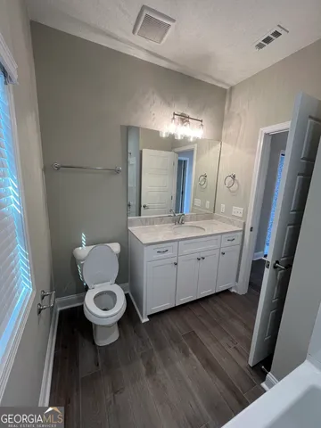 a view of an empty room with window and cabinet