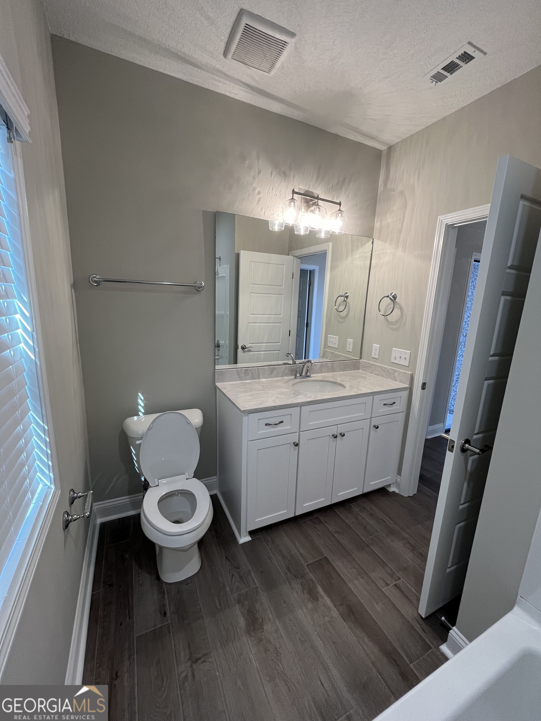 160 The Villas Way Kingsland, GA 31548 - Photo 11 of 65 a bathroom with a sink toilet a mirror and vanity