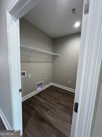 a view of a livingroom with a kitchen island wooden floor and ceiling fan