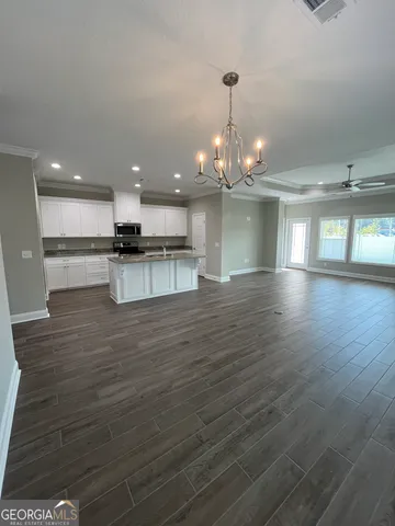 a view of kitchen with stainless steel appliances granite countertop cabinets and wooden floor