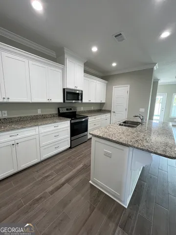 a kitchen with granite countertop a cabinets and a stove top oven