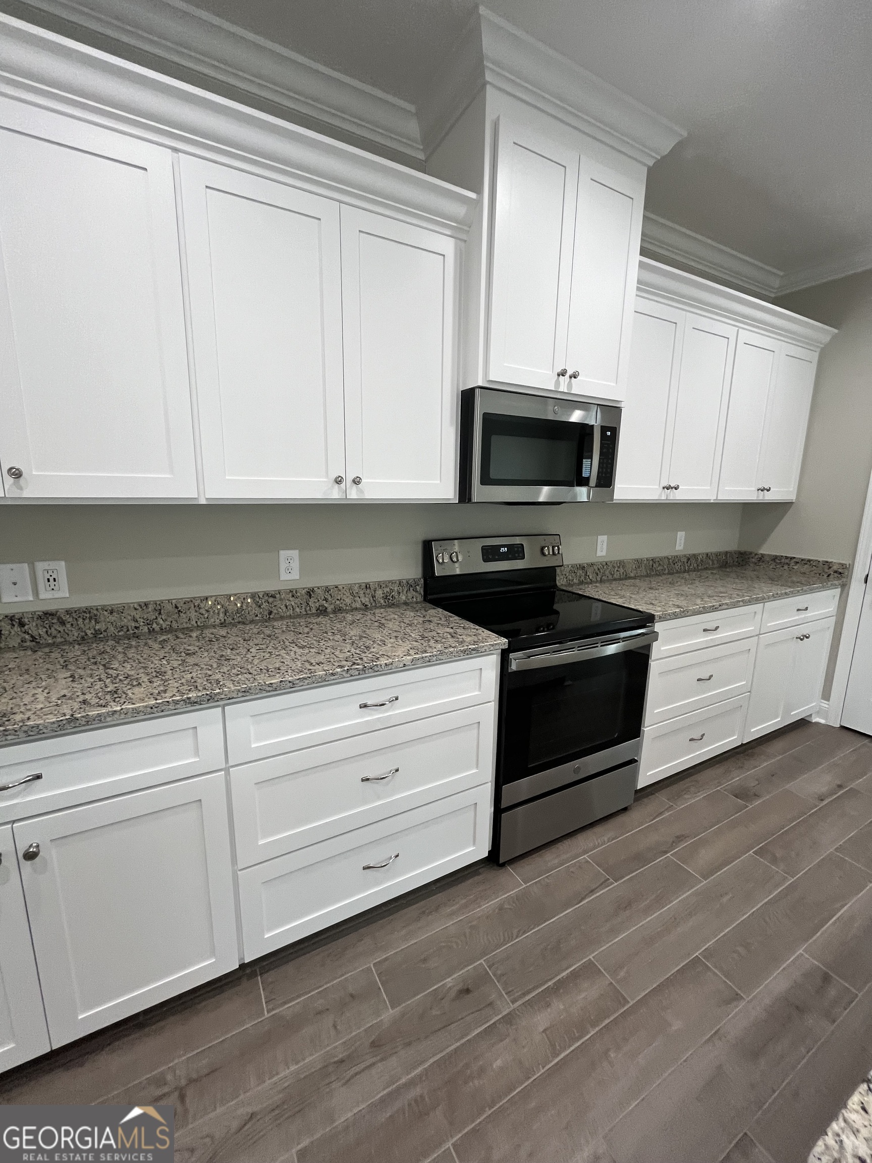 160 The Villas Way Kingsland, GA 31548 - Photo 30 of 65 a kitchen with granite countertop white cabinets and stainless steel appliances