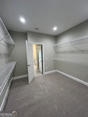 a view of a house with a yard and large trees