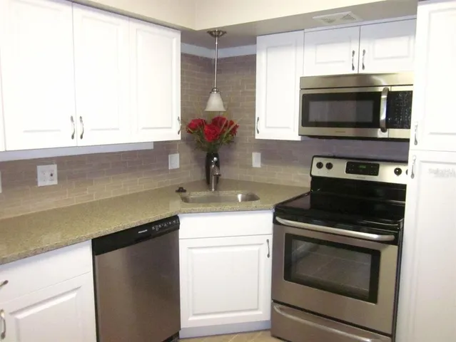 a kitchen with a sink cabinets and a window