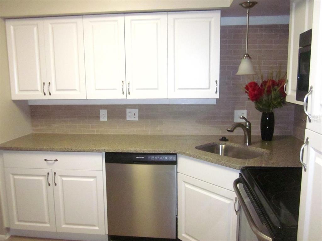 2456 Ecuadorian Way, Unit 46 Clearwater, FL 33763 - Photo 4 of 65 a kitchen with a sink cabinets and a window