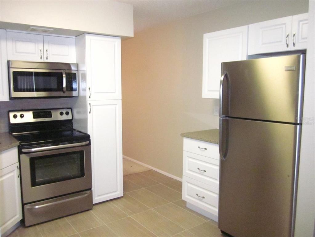 2456 Ecuadorian Way, Unit 46 Clearwater, FL 33763 - Photo 5 of 65 a kitchen with white cabinets and stainless steel appliances