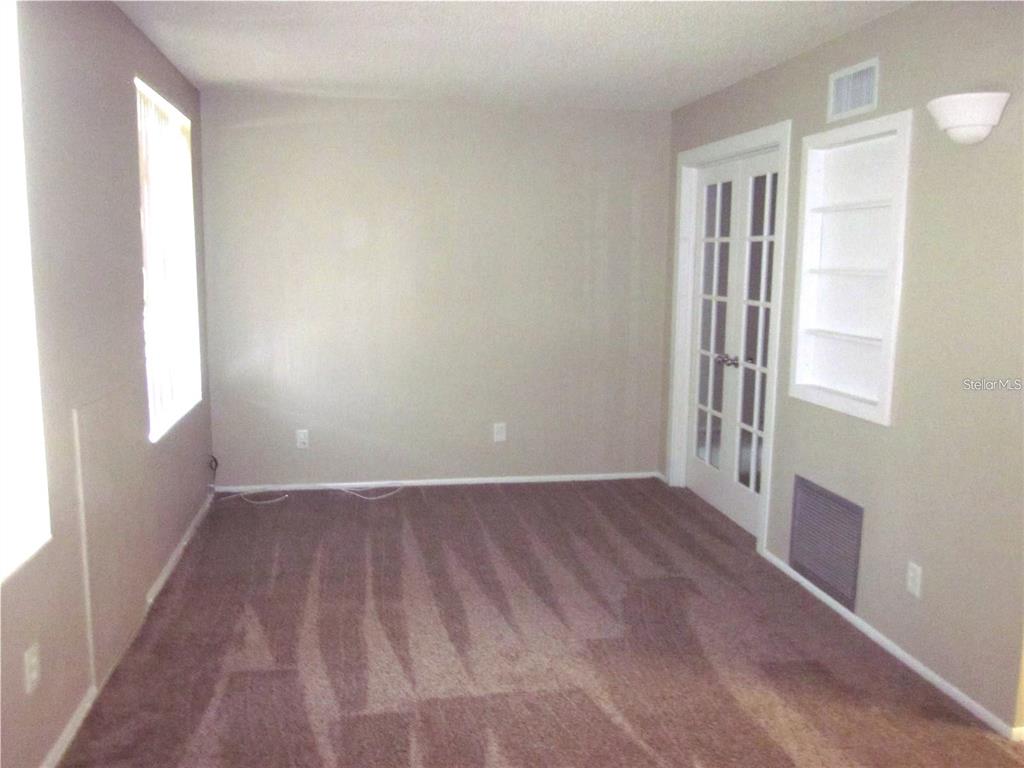 2456 Ecuadorian Way, Unit 46 Clearwater, FL 33763 - Photo 7 of 65 a view of an empty room with wooden floor and a window