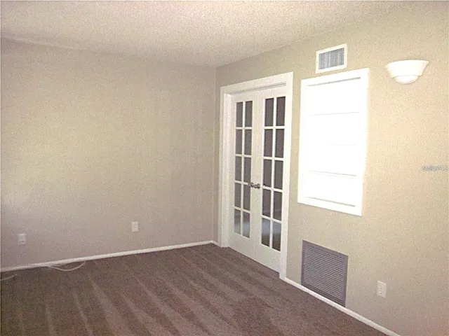 an empty room with a fan & a window