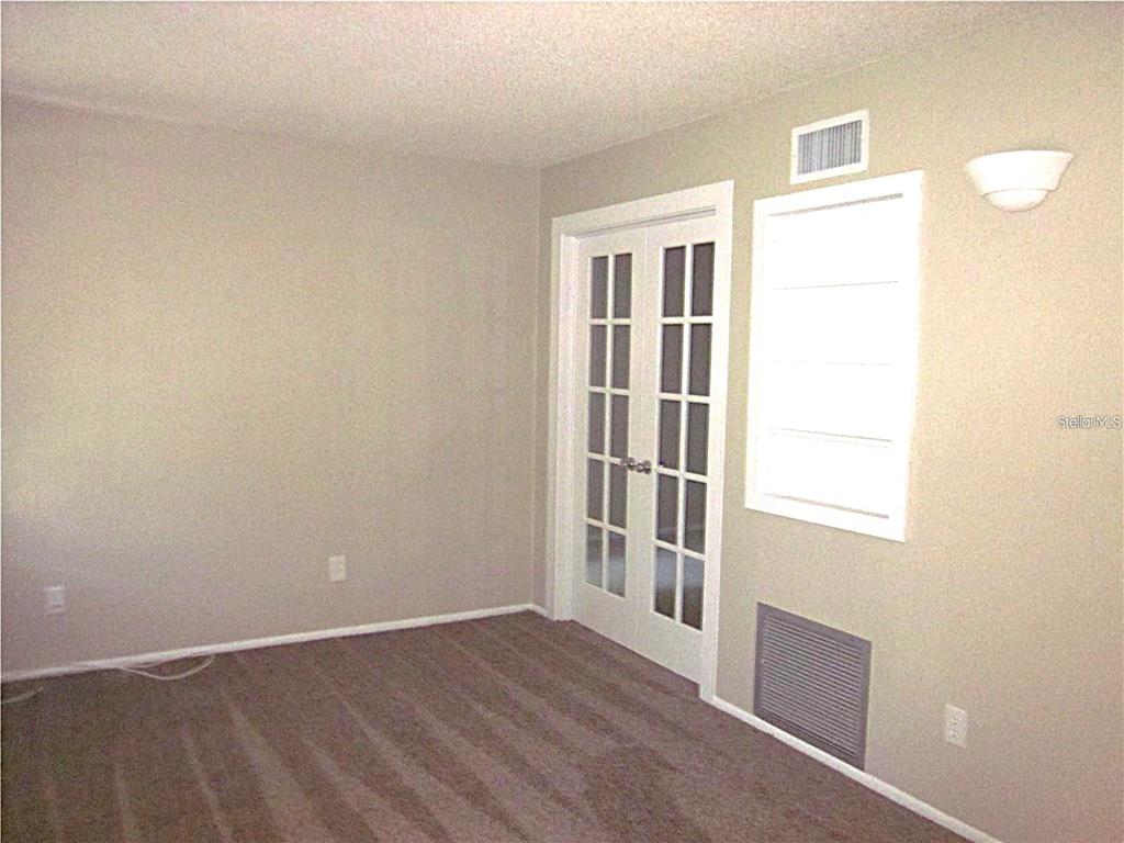 2456 Ecuadorian Way, Unit 46 Clearwater, FL 33763 - Photo 8 of 65 an empty room with wooden floor and windows