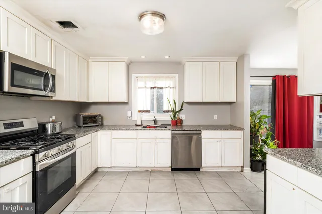a kitchen with stainless steel appliances granite countertop a stove top oven a sink dishwasher and a refrigerator