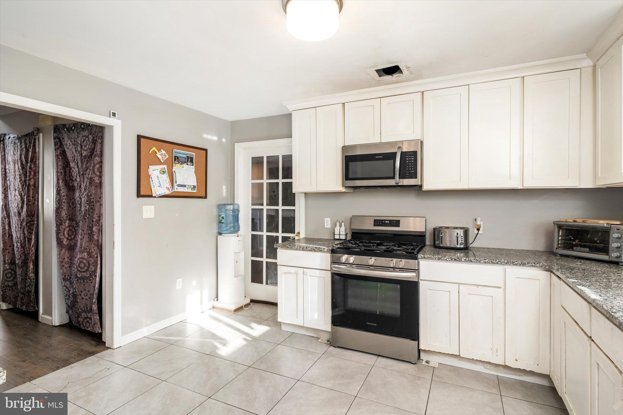 355 Leonard Avenue Hamilton, NJ 08619 - Photo 8 of 34 a kitchen with stainless steel appliances granite countertop a stove top oven a refrigerator and white cabinets