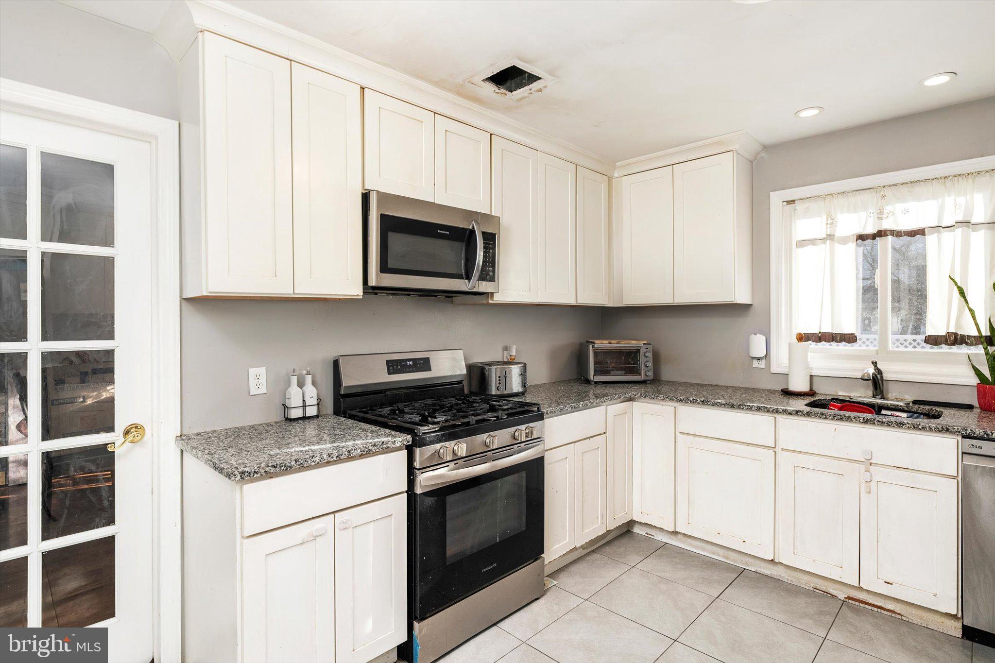 355 Leonard Avenue Hamilton, NJ 08619 - Photo 10 of 34 a kitchen with granite countertop white cabinets sink and stainless steel appliances