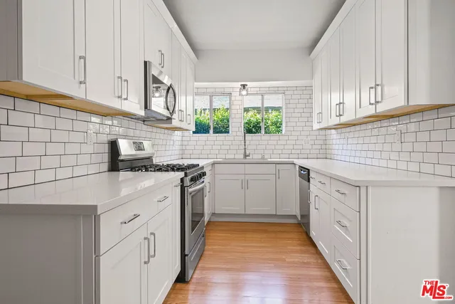 a kitchen with white cabinets and white appliances