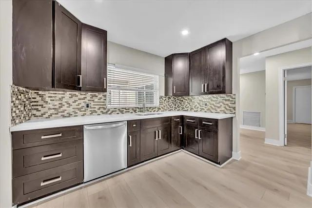 a kitchen with stainless steel appliances kitchen island granite countertop a sink and wooden cabinets