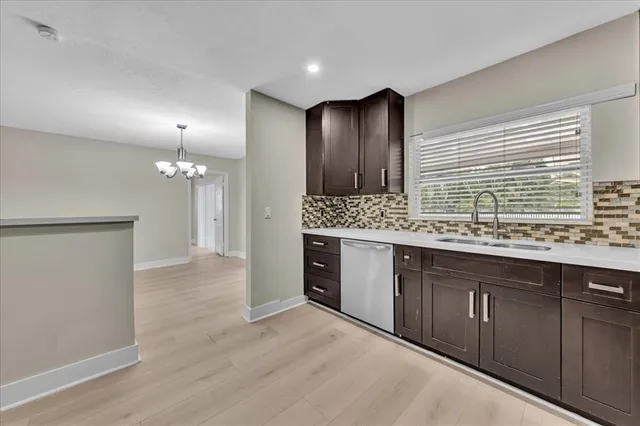 a kitchen with granite countertop stainless steel appliances a refrigerator cabinets and wooden floor