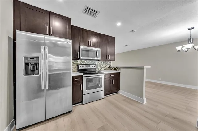 a kitchen with stainless steel appliances granite countertop a stove refrigerator and cabinets