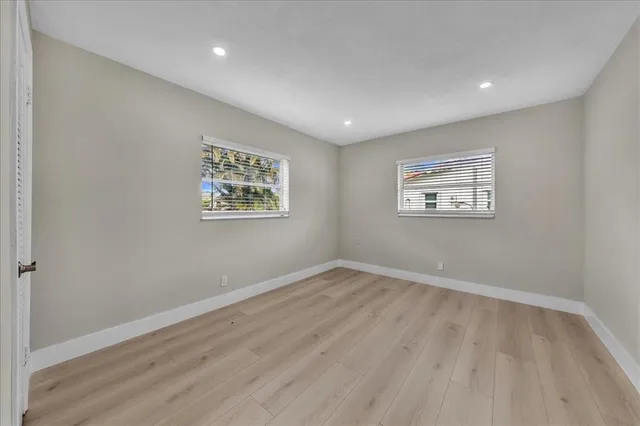 a view of an empty room with wooden floor