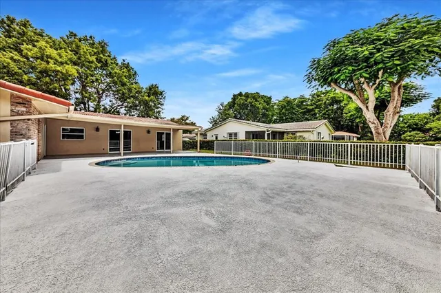 a view of a house with a small yard and wooden fence