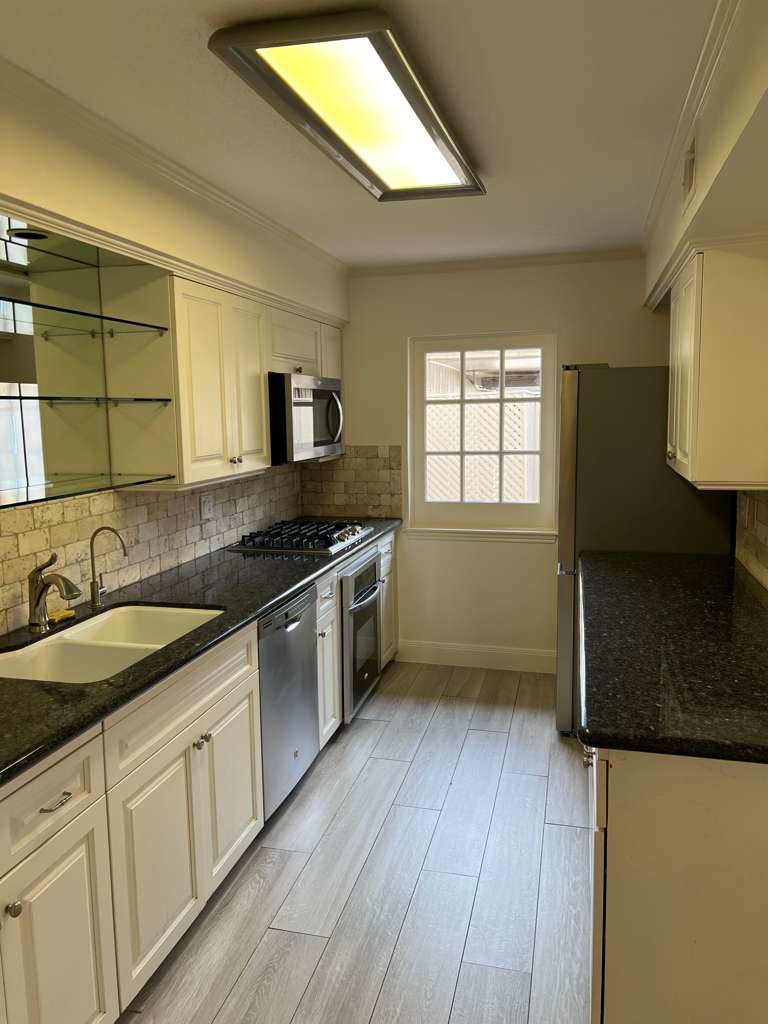 5817 Valley Forge Drive, Unit 90 Houston, TX 77057 - Photo 8 of 21 a kitchen with granite countertop a stove a sink and a microwave
