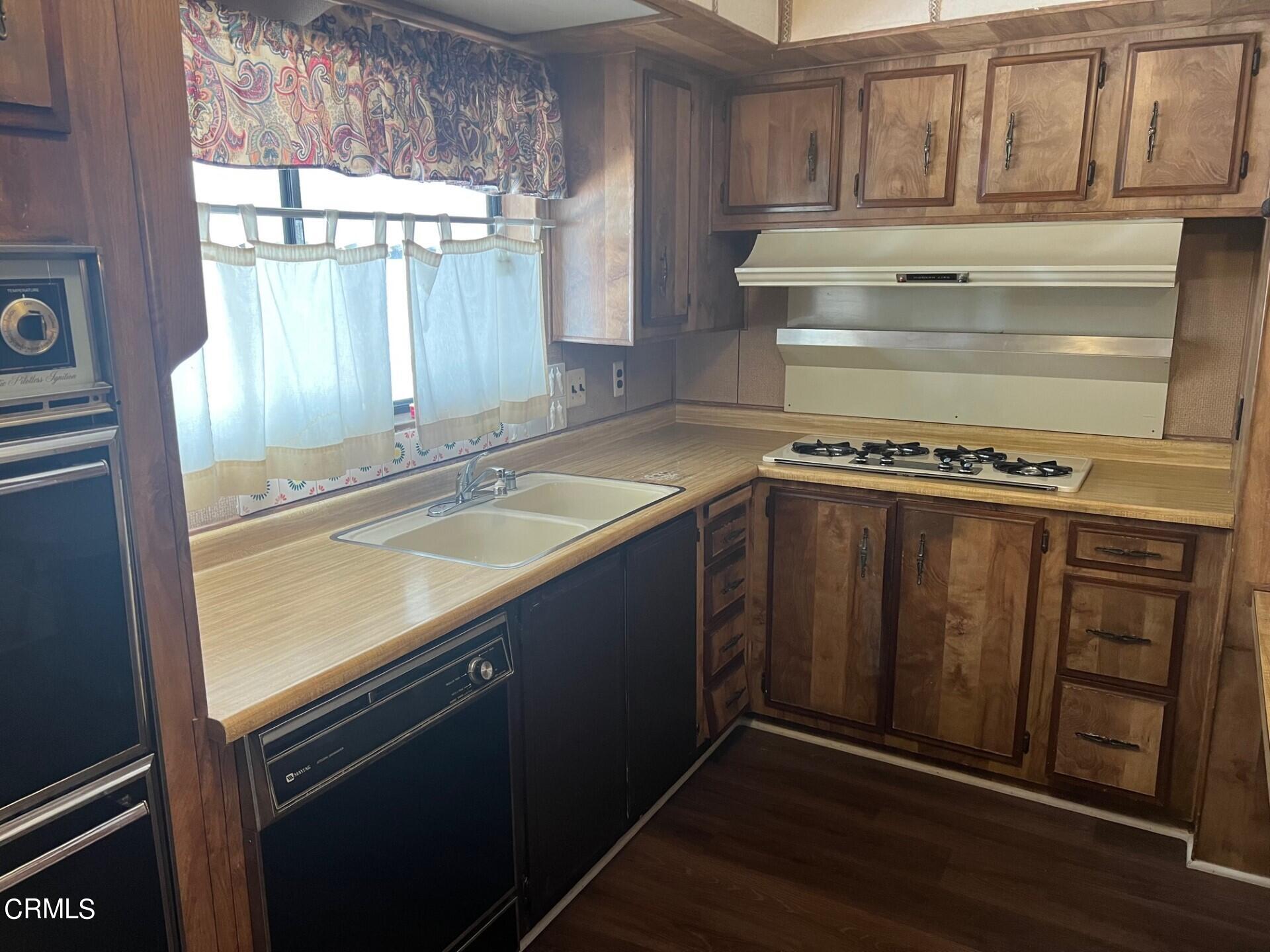 3700 Olds Road, Unit 86 Oxnard, CA 93033 - Photo 3 of 12 a view of a kitchen with wooden floor and a sink