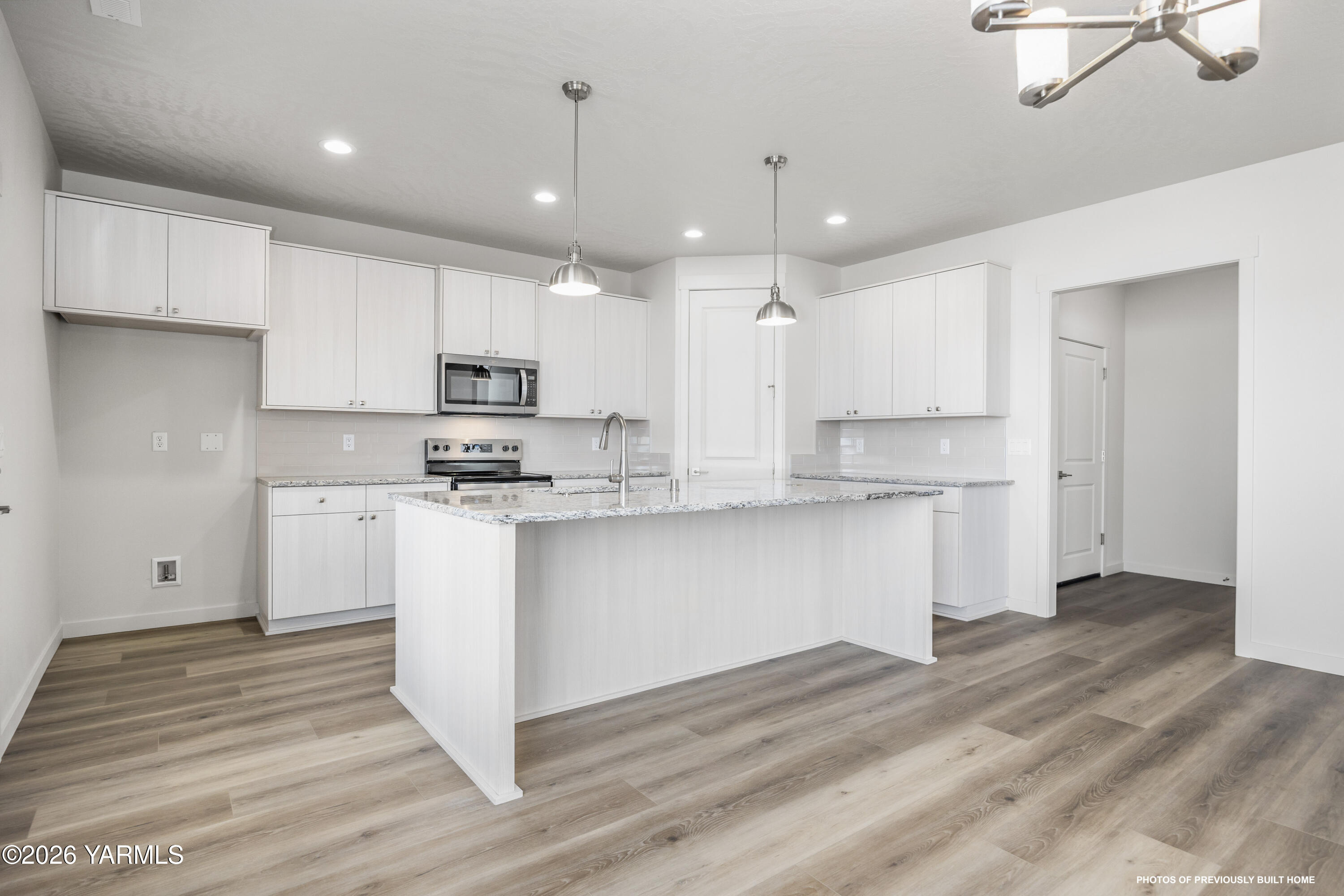 215 Packer Street Prosser, WA 99350 - Photo 29 of 38 a kitchen with granite countertop white cabinets and stainless steel appliances