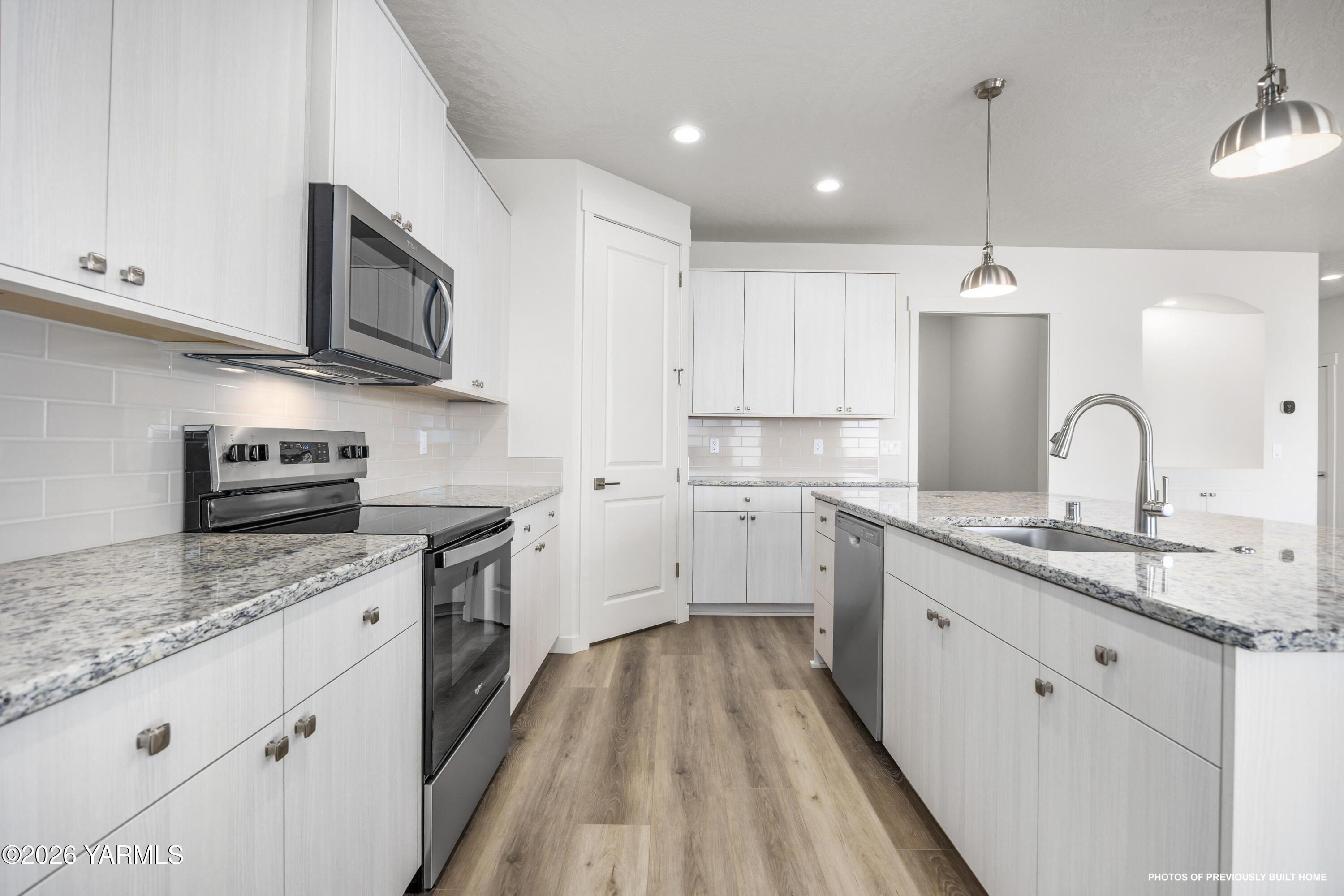 215 Packer Street Prosser, WA 99350 - Photo 30 of 38 a kitchen with stainless steel appliances granite countertop a sink a stove and a wooden floors