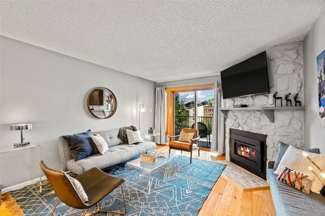 a living room with furniture a flat screen tv and a fireplace