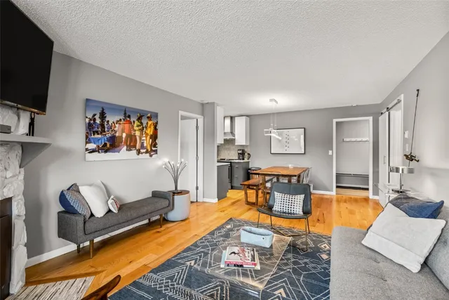 a living room with furniture kitchen view and a flat screen tv