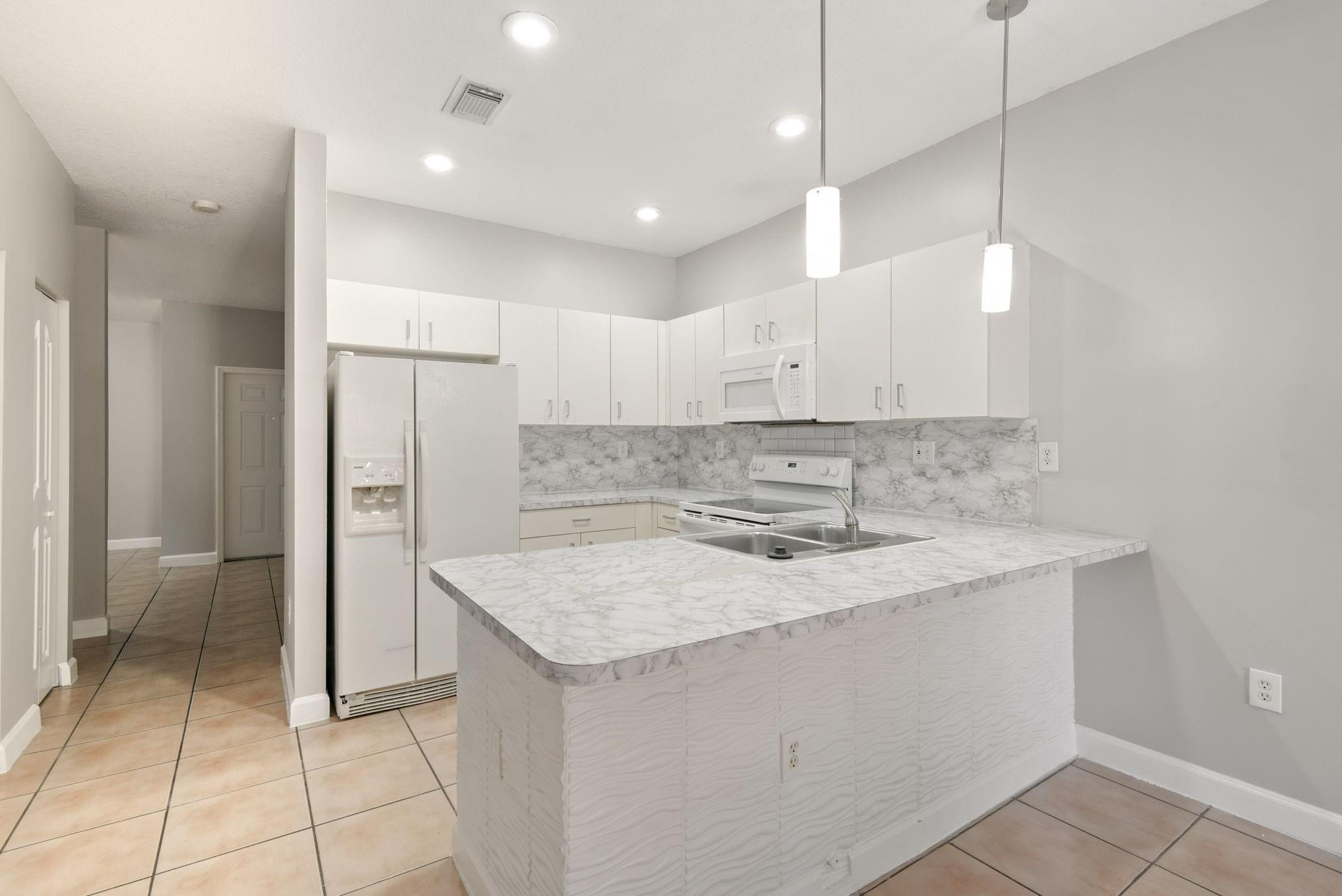 11368 Southwest 230th Terrace Miami, FL 33170 - Photo 9 of 37 a kitchen with a sink a refrigerator and a stove