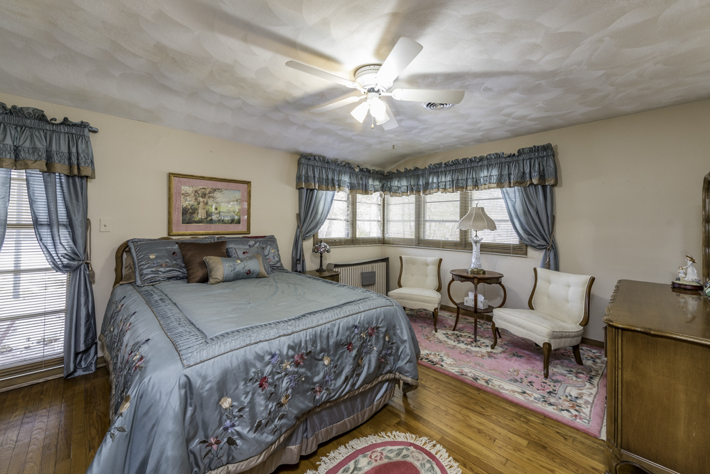 1118 Shiloh Boulevard Zion, IL 60099 - Photo 21 of 33 a bedroom with a bed and a large window with wooden floor
