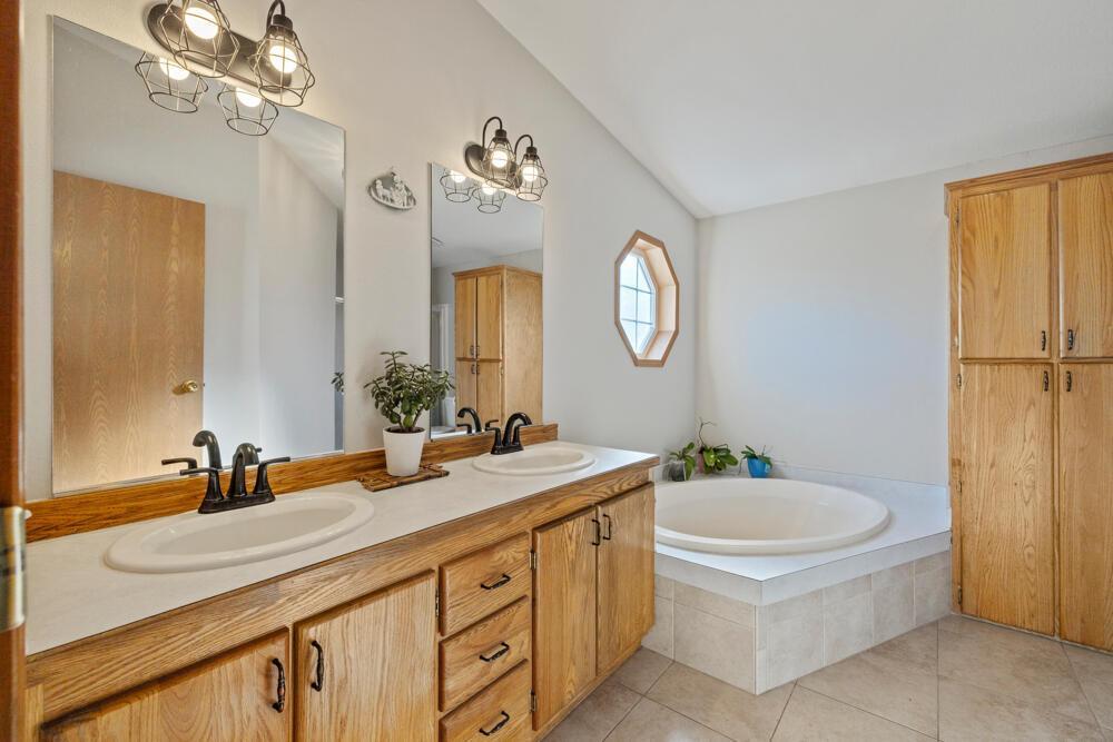 17550 South Poe Valley Road Klamath Falls, OR 97603 - Photo 27 of 59 a bathroom with a double vanity sink a mirror and a bathtub