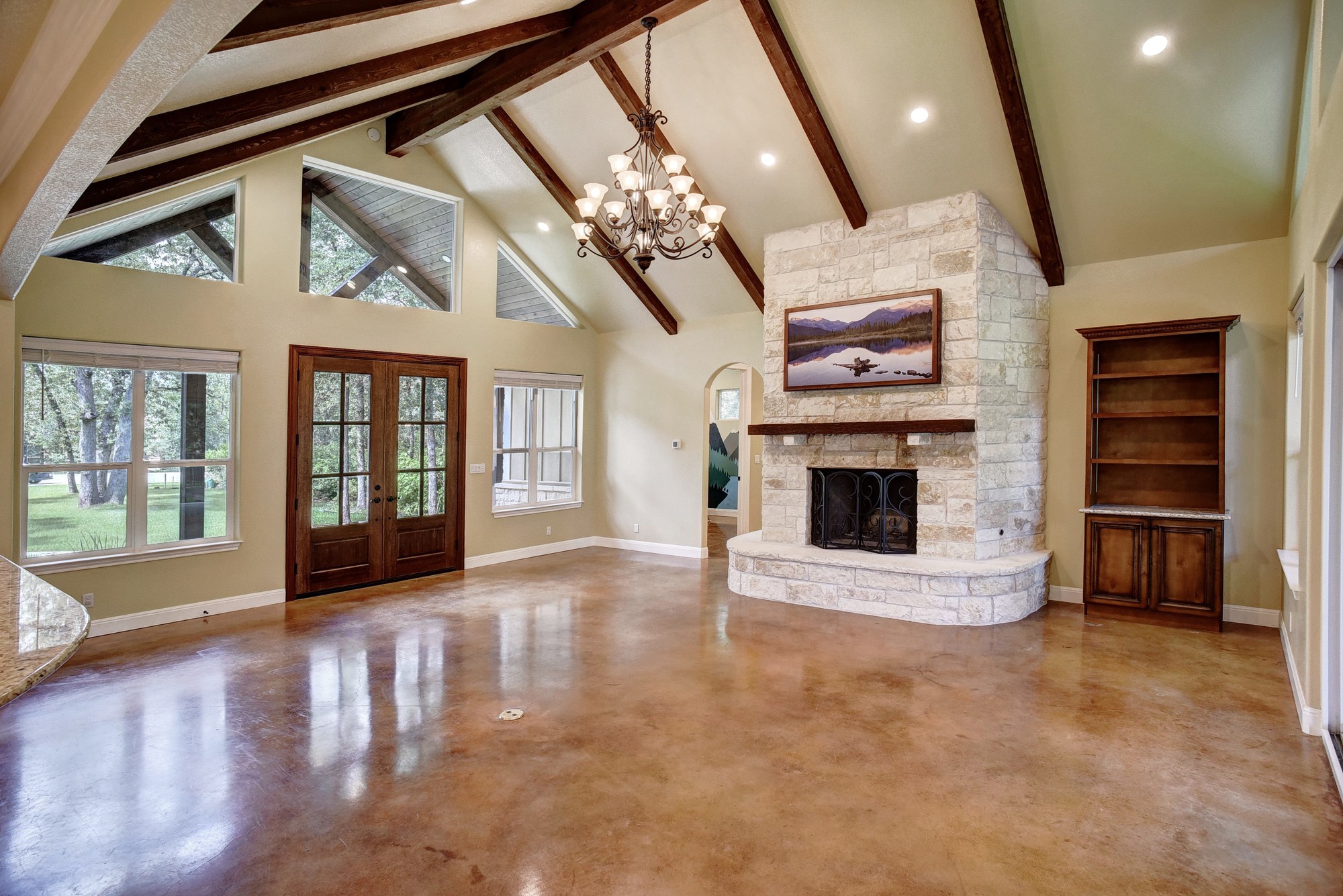 115 Pine Point Cove Elgin, TX 78621 - Photo 6 of 39 A spacious living area offers vaulted ceilings with exposed beams and a captivating stone fireplace.