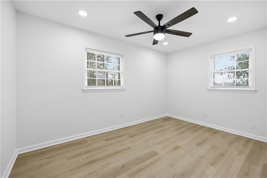 2095 Mulkey Road Southwest Marietta, GA 30008 - Photo 20 of 32 an empty room with wooden floor and ceiling fan