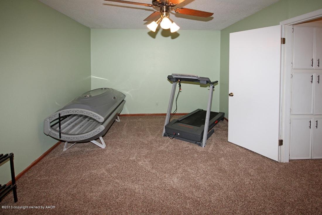 5216 Leland Drive Amarillo, TX 79110 - Photo 11 of 23 a room with gym equipment and a chandelier