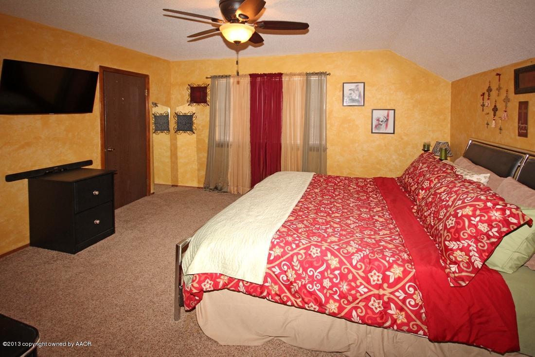 5216 Leland Drive Amarillo, TX 79110 - Photo 16 of 23 a bedroom with a bed and a flat screen tv