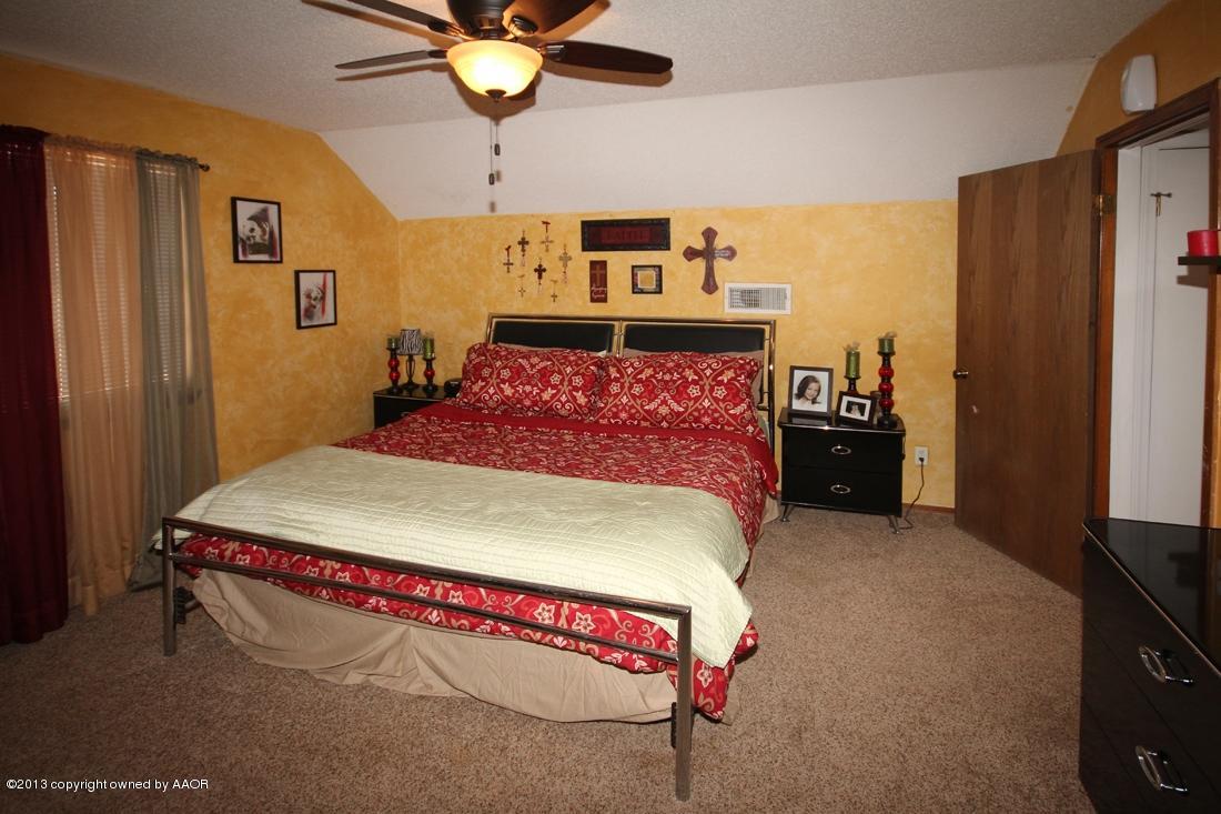 5216 Leland Drive Amarillo, TX 79110 - Photo 17 of 23 a bed room with a bed and a chandelier
