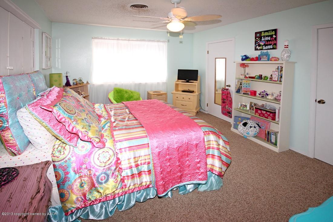 5216 Leland Drive Amarillo, TX 79110 - Photo 19 of 23 a bedroom with a bed and a tv in it